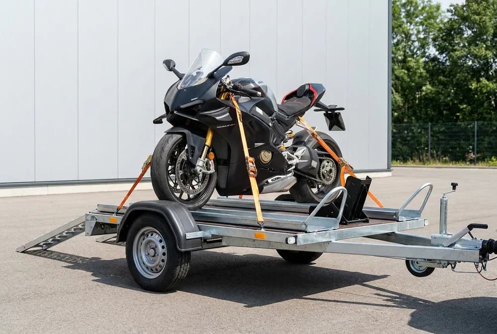 Porte-moto à essieu unique avec rampe de chargement, une moto sportive sanglée